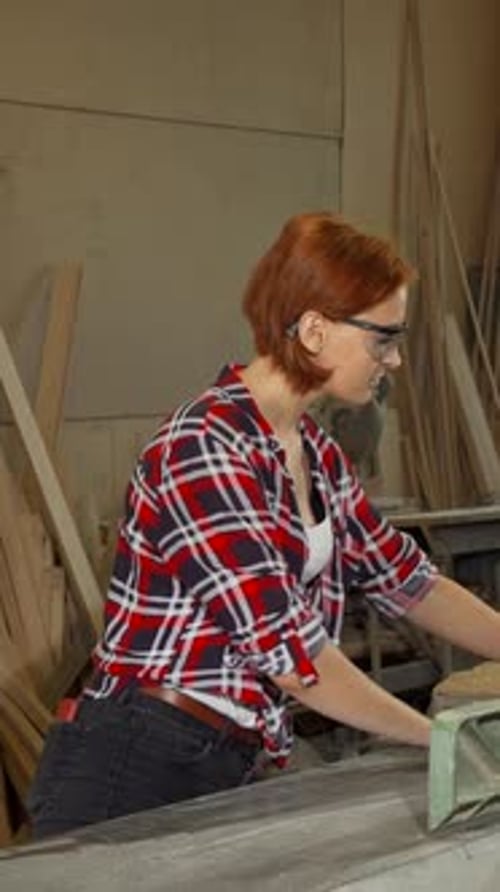Focused Female Carpenter Skillfully Working with Power Tools in Her Vibrant Workshop