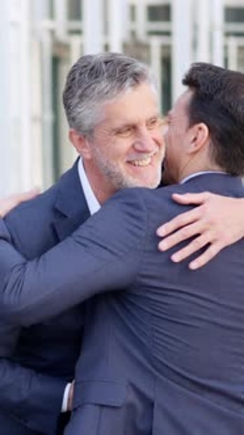 Two Men Embrace Happily After a Business Meeting