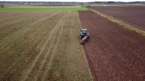 Tractor Tilling Soil in Rural Field