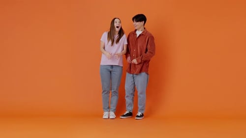 Joyful Asian Man Tells Secret in Ear of Woman in Premise