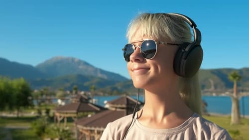 Woman Listening to Music With Headphones Outdoors
