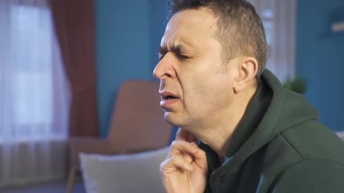 Dor de garganta. O homem com a sensação de irritação e queimação na garganta.