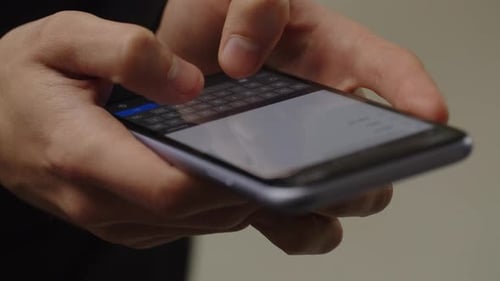 Cropped View of a Smartphone User Tapping on the Screen Male Hands Typing a Message on a Smartphone