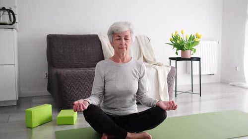 Senior Woman Sitting In Yoga Lotus Position
