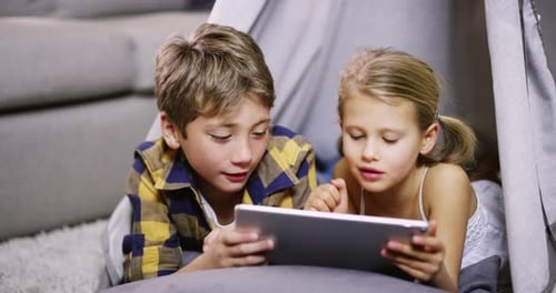 Two Children Playing Tablet in Homemade Tent