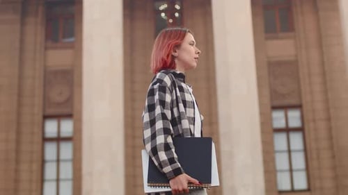 Young Woman Uses Phone Outside of Building