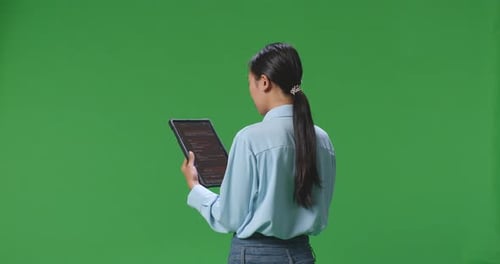 Business Woman Using Tablet On Green Screen Background In The Studio, Tablet Display Showing Code