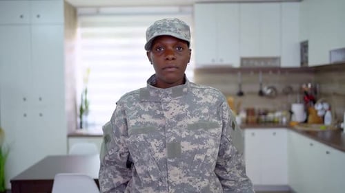 Woman in Camouflage Uniform in Home Kitchen Setting