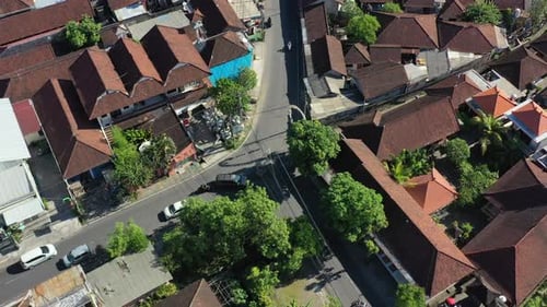 aerial top down of cars and motorbikes driving in a residential neighborhood in bali indonesia
