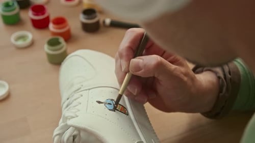 Artist Paints Custom Design on White Shoe