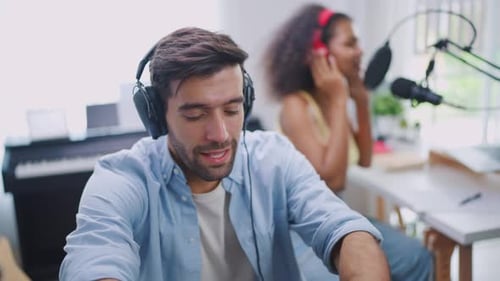 Diverse young stylish audio producer working in the music record studio.