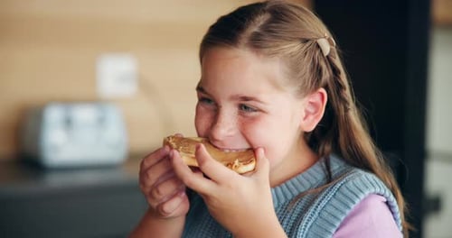 Girl Eating Toast with Peanut Butter in Kitchen