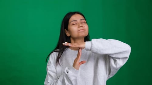 Time Out Gesture Woman in a Studio Shot Showing a Hand Sign for Break or Pause Indicating the Need