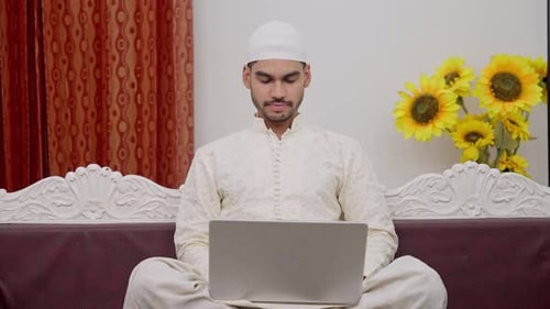 Homme musulman travaillant sur un ordinateur portable et dormant