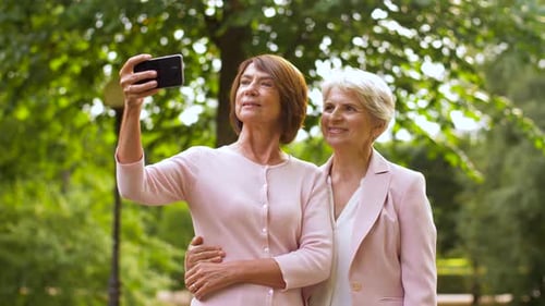 Women Taking Selfie Outdoors in Green Urban Park