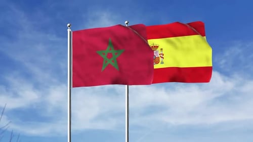 Waving Flags of Morocco and Spain against Blue Sky