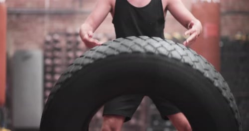 Adult male flipping tire for a body building workout