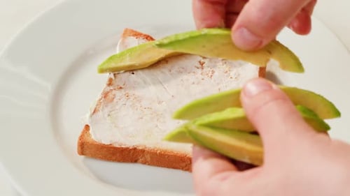 Preparing Avocado Toast with Cream Cheese, Close Up