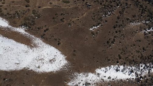 Aerial View of Deserted Terrain Partly Covered By Snow
