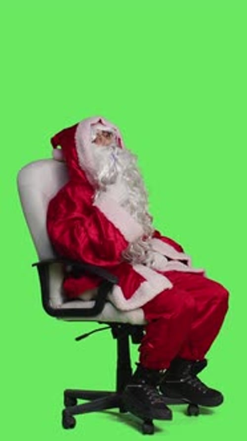 Vertical Video Side View of Thoughtful Santa in Red Suit on Chair