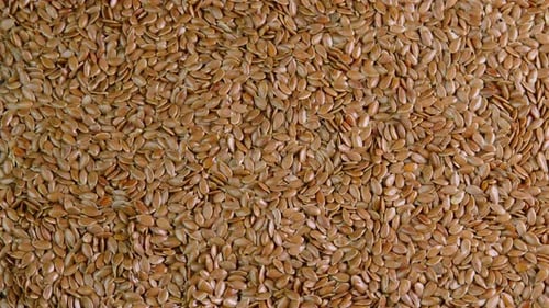 Linseed rotating background top view close up. Flax seeds rotate. Healthy nutrition, dieting