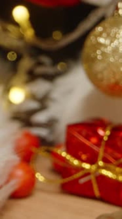 Vertical video. The camera passes through a candle into Santa's hat, which is lying on the table. Ch
