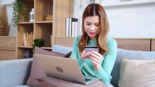 Woman Uses Laptop with Credit Card at Home