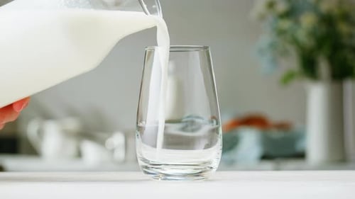 Milk Pouring in Glass Cup Closeup Glass with Yogurt Dairy Products Concept Drinking Fresh