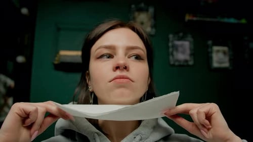 Interior de un estudio de piercings: el maestro de piercings hace un piercing para una niña, piercing para el tabique nasal