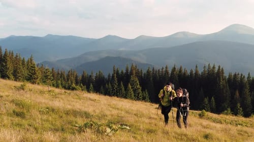 Couple of tourists walks up on hill. Majestic Carpathian Mountains. Beautiful landscape of untouched