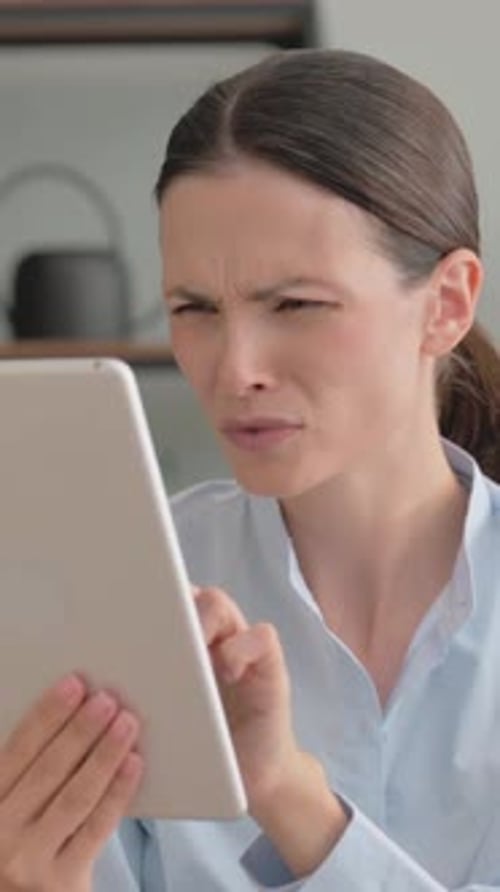 Woman Looks at Tablet with Frustration and Despair
