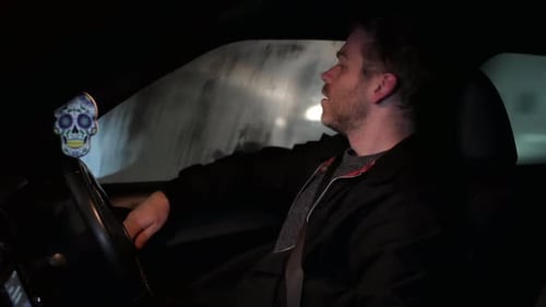 An angry driver at night. A man is shouting in a traffic jam in a city