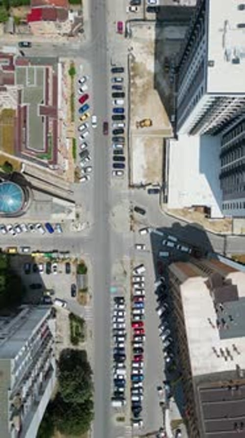 Topdown View of a City Block with Residential Buildings Green Spaces and Parked Vehicles The Image