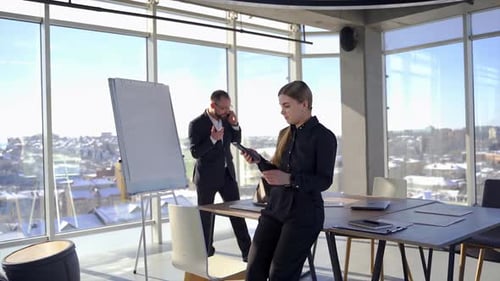 Business colleagues work in office room. Entrepreneur man in suit talking the phone.