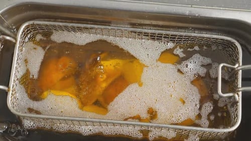 Slices of Potatoes Rustic is Frying in Hot Boiling Oil at Cuisine Pieces of Potatoes Village Fries