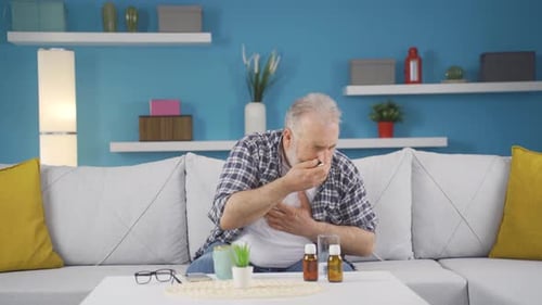 Man covering mouth and nose while sneezing.