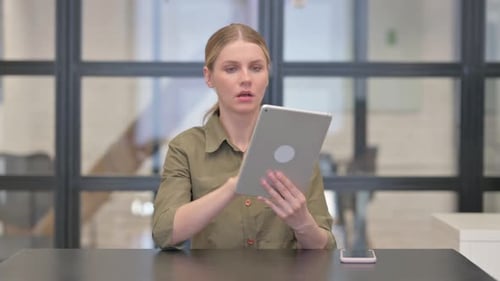 Woman Using Tablet Looks Worried at Table
