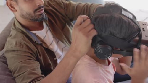Father Helping Child Play With VR Headset