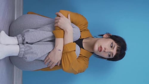 Woman Sitting on Floor Looks Sad