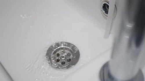 Water Flowing Down Sink Drain Close Up