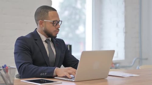 Professional Man Working on Laptop in Modern Office