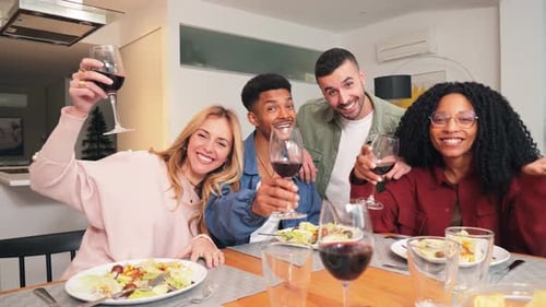 Friends Toasting With Wine at an Indoor Dinner