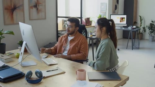 Diverse IT Engineers Bumping Fists After Testing New AI Software on Computer