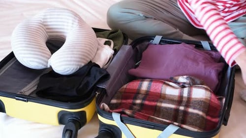 Person Packing a Suitcase for a Trip