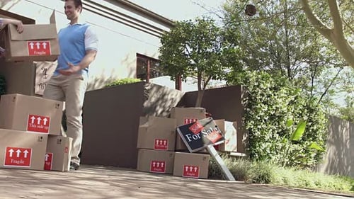 Man and Woman Moving Boxes into New Home