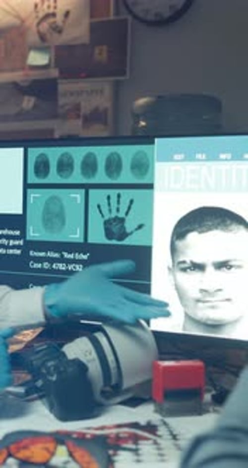 Gloved Hand Examines Fingerprint Evidence on Screen