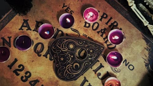 Spirit Board with Candles and Planchette Overhead Shot