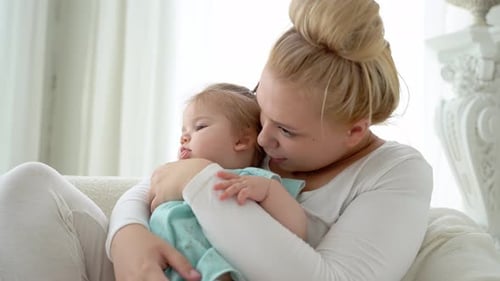 Mother embrace baby girl at home. Family love in bedroom. Happy lifestyle childhood. Parent hug chil