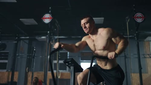 Cardio Workout in Modern Fitness Center Attractive Sportive Man with Torso Training on Exercycle