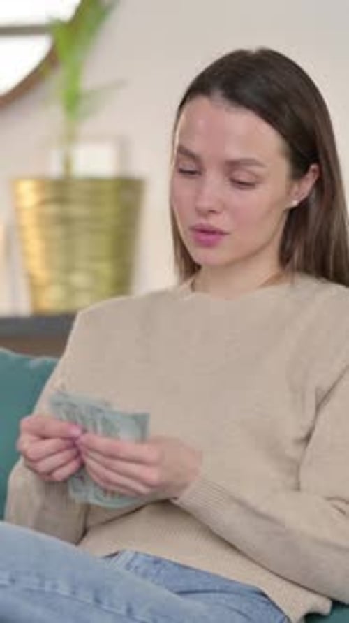 Successful Young Woman Counting Dollar on Sofa, Vertical Video